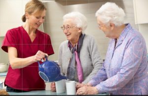An attendant pouring tea for two older women