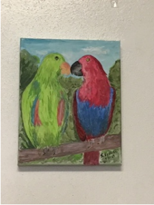 A painting of two parrots hung on a wall