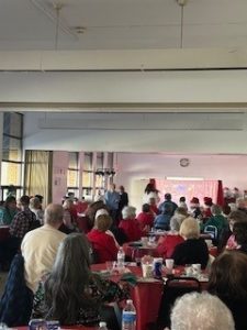 A room full of people having refreshments and chatting during the holiday party 2023