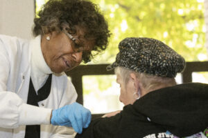 A nurse gives a check up to an older woman