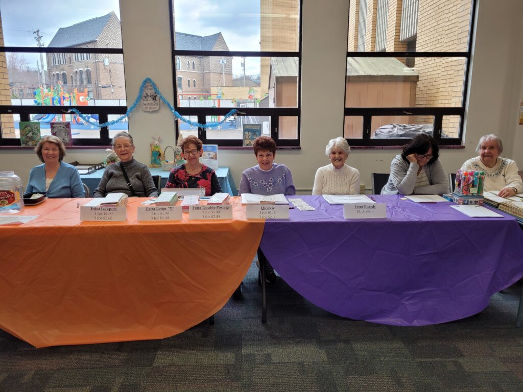 Volunteers seated behind tables organizing bingo games and prizes at Turtle Creek Senior Center event.