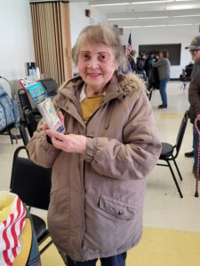 An older woman holds the cash and scratch cards she won at Bingo Bash